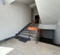 In the office interior, there is a staircase with stone steps and a wooden railing.