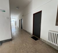 Hallway with tiles, emergency exit, and office doors.