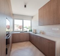 A kitchen in a family house with a window and a wooden decor floor.