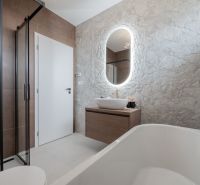A bathroom in a family house with a stone wall, a sink, and a shower.