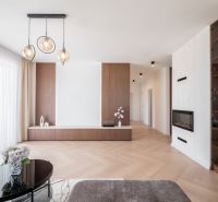 Interior with wood-patterned flooring, glass table, and built-in fireplace in a family house.