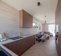 Kitchen and living room in a family house with a wooden decor floor.