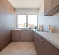 A kitchen with a corner unit and a wooden decor floor in a family house.