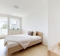 Bedroom in a two-room apartment with a bed and a wardrobe, floor with wooden decor.