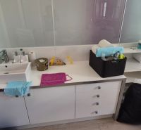 Sink with storage space, cleaning products and home accessories in the office.