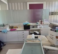 Offices with a counter, sink, and couch, floor with wooden decor.