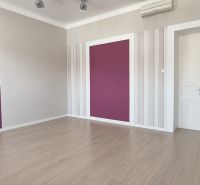 Offices with a purple wall and wood-patterned flooring.