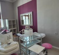 An office interior with white furniture, a mirror, and a wooden-patterned floor.