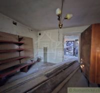 The interior of a family house with shelves and a chandelier appears neglected.