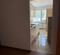 A view from a 3-room apartment to the kitchen with a tiled floor.