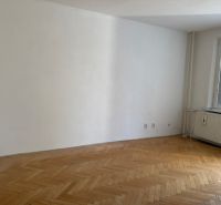 A room in a 3-room apartment with a light wall and a wooden decor floor.
