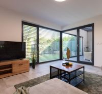 Living room in a 4-room apartment with a wood-patterned floor and large windows.