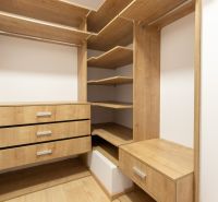 A wardrobe with shelves and drawers made of wood in a 4-room apartment.