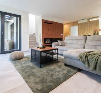 A spacious living room with a sofa, carpet, and transparent doors in a 4-room apartment.