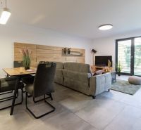 Living room in a 4-room apartment with large windows and comfortable seating furniture.