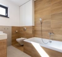 A bathroom in a 4-room apartment with a wood-patterned floor and a bathtub.