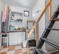 A staircase with storage space and a kitchen unit in a family house.