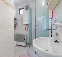 A bathroom in a family house with tiles and a shower corner.