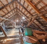 The attic in a family house with wooden beams and stored items.