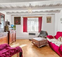 Living room in a family house with a wooden decor floor and red seating.