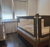 Children's room with a bed, barrier, and floor with wooden decor in a 3-room apartment.