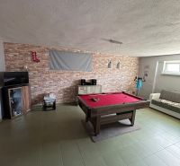 Game room in a family house with a pool table and a brick wall.
