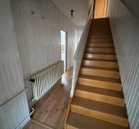Interior of a family house with a wooden staircase and a floor with a wood decor.