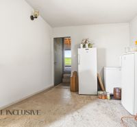 Storage space in a family house with refrigerators and shelves, floor with wooden decor.
