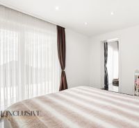 Bedroom with a baby crib, wall decoration, and a large window in a family house.