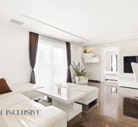 A living room of a family house with soft lighting, a wooden decor floor, light seating.