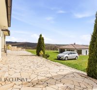 A garden terrace by a family house in Kopanice in Krupina with a view and a parked car.