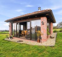 A family house on Kopanice Street in Krupina, with a glass wall and a landscaped garden.