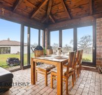 Dining room in a family house with brick walls, a table, and a view of the garden.