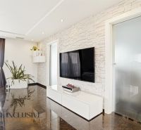 Living room with a TV on the wall and a wooden decor floor in a family house.
