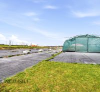 The exterior of a family house on Kopanice Street in Krupina, greenhouse, concrete area, clear sky.