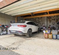 The garage of a family house in Kopanice, Krupina with a white car and trophies.