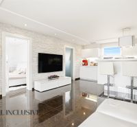 Living room in a family house with white furniture and a kitchenette.