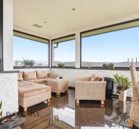 Windows and wicker furniture in a family house, wooden decor flooring, view of the countryside.