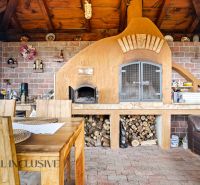 A fireplace with brick cladding and wooden decor in a family house, interior with seating area.