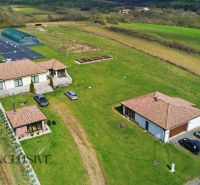 Family houses in Kopanice in Krupina surrounded by greenery and cars in the parking lot.