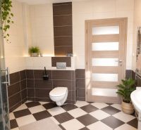 A bathroom in a 3-room apartment with brown-beige tiles and a shower.