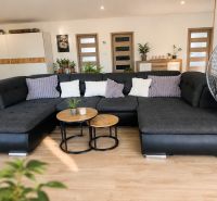 Living room with a large sofa, tables, and a wooden decor floor in a 3-room apartment.