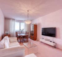 Living room in a 4-room apartment with a sofa, TV, and dining table.