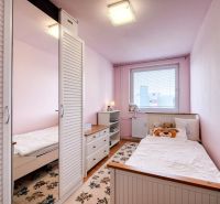 Children's room in a 4-room apartment with white wardrobes and floral-patterned carpets.