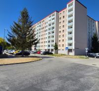 A residential building on E. F. Scherer Street in Piešťany, surrounded by trees and a parking lot.