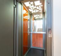 Open elevator with LED panels in a 4-room apartment, floor with wood decor.