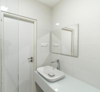 A bathroom with a mirror, sink, and white tiles in a 4-room apartment.