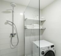 A bathroom in a 4-room apartment with a shower and a washing machine.