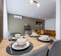 Dining table with serving and a view of the sofa in a 3-room apartment.