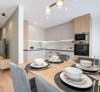 Modern kitchen with a dining table in a 3-room apartment, floor with wood decor.